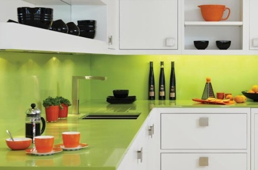 Spilgtas kaļķa nokrāsas countertop un priekšauts izskatās lieliski kombinācijā ar baltām virtuves fasādēm un oranžiem ēdieniem.
