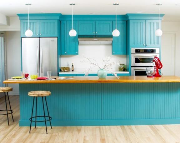 Tirkīza krāsas virtuves komplekts apvienojumā ar gaišām sienām un grīdu
